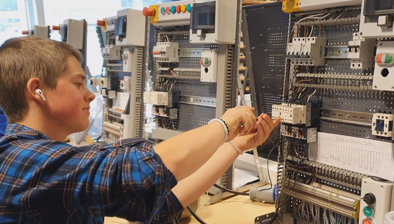 Bilete av ein elev som har praktisk undervisning i elektro verkstaden